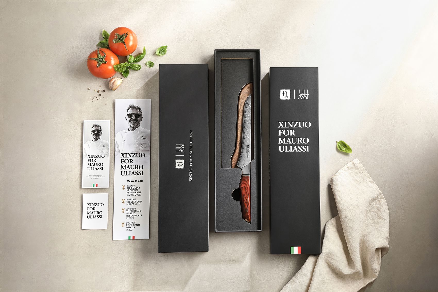 XINZUO for Mauro Uliassi black gift box open to reveal the Damascus boning knife, with branded sleeve, chef booklet and Italian-flag tag