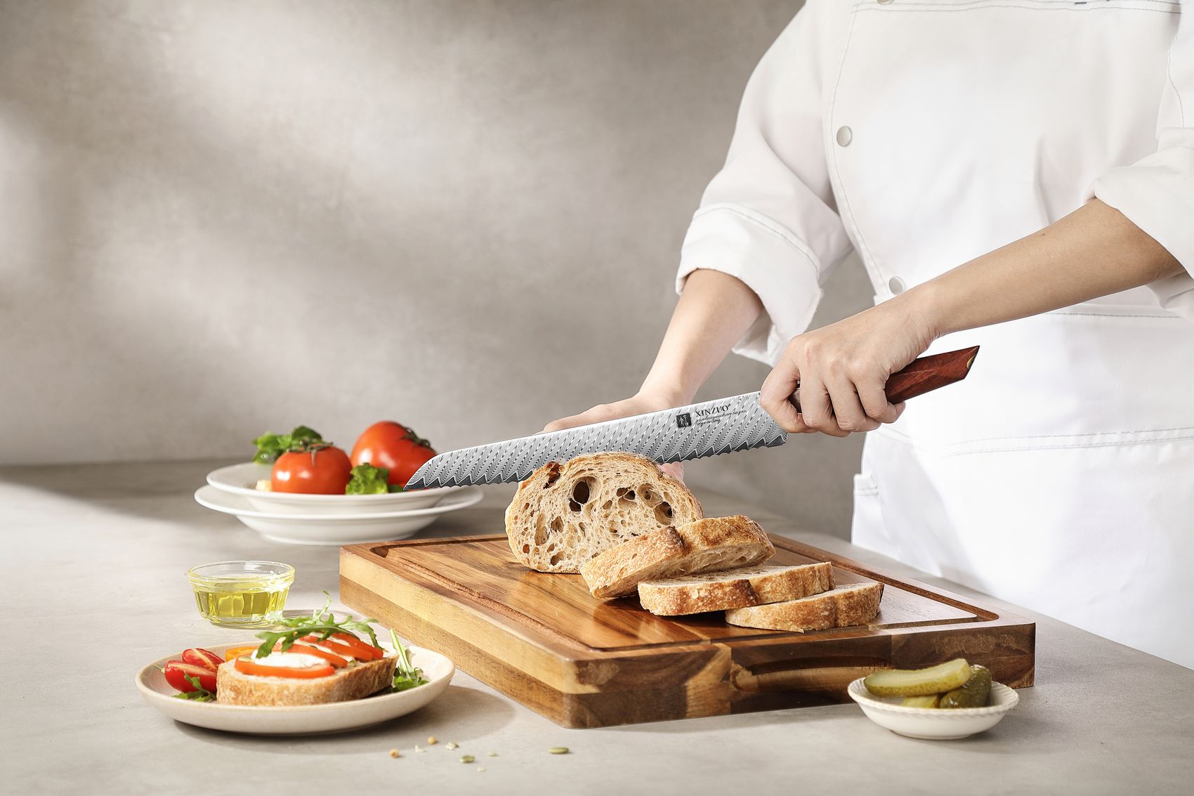 Chef slicing a rustic sourdough loaf with the 10-inch Damascus bread knife on a wooden board