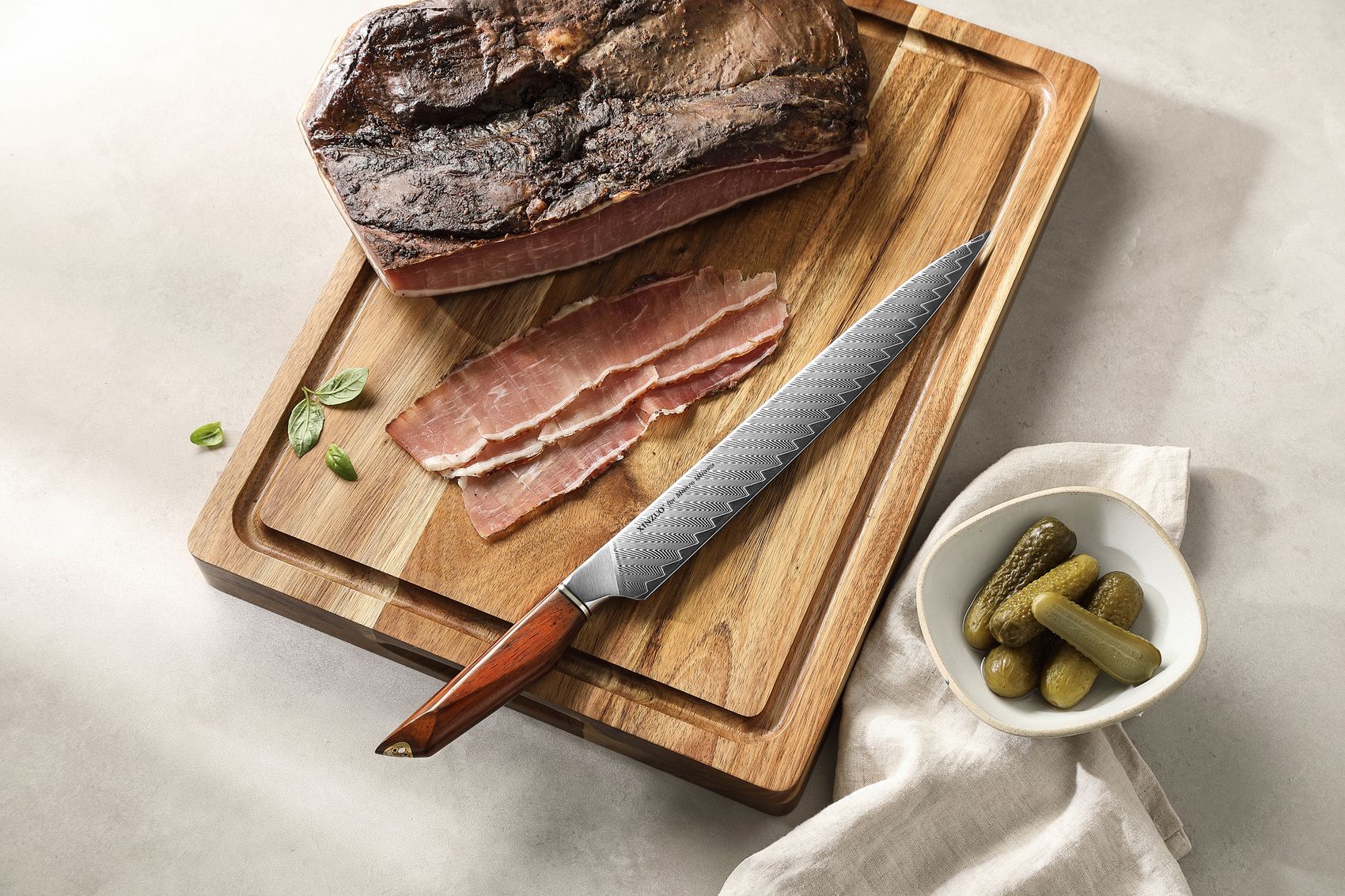 Carved roast beef and the Damascus knife on a wooden cutting board with olives