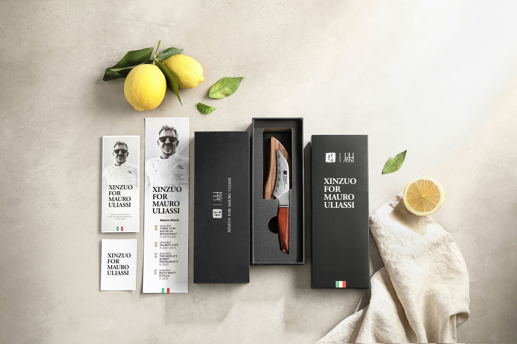 XINZUO for Mauro Uliassi gift box open showing the paring knife in its tray beside chef booklets and lemons