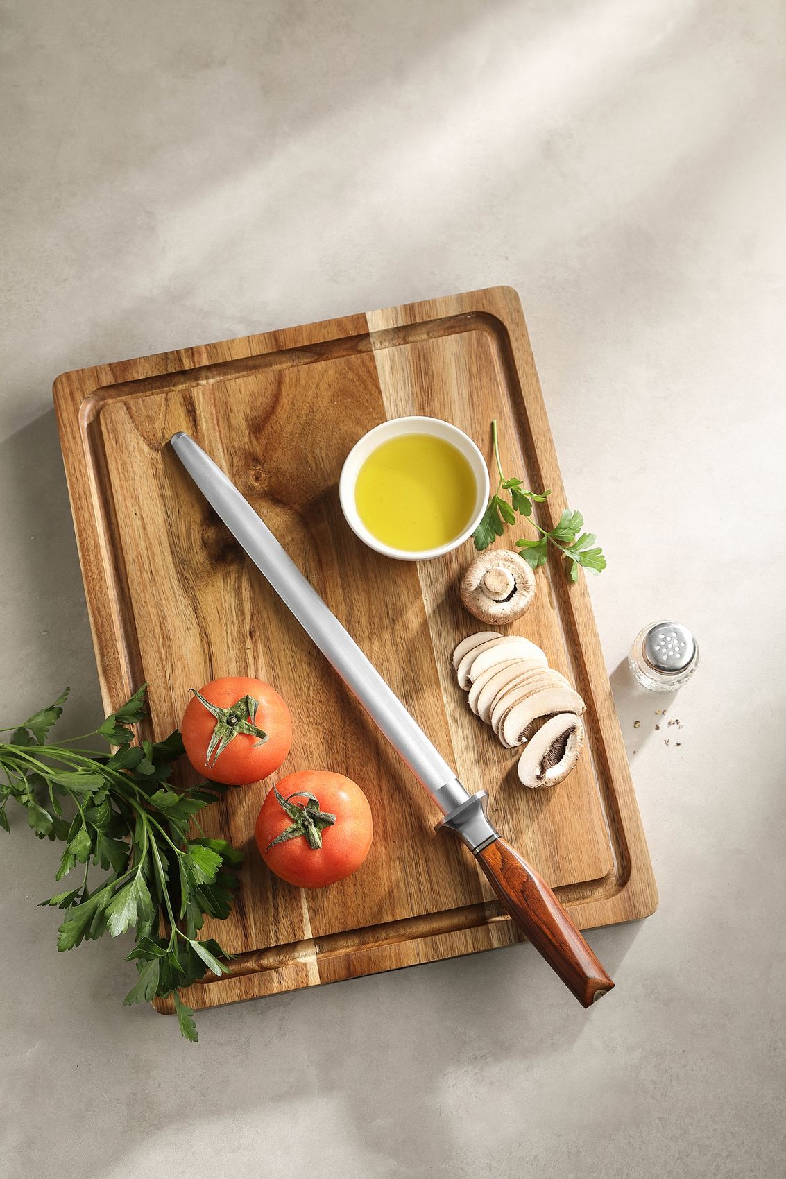 X03 honing rod on a board with tomatoes and herbs
