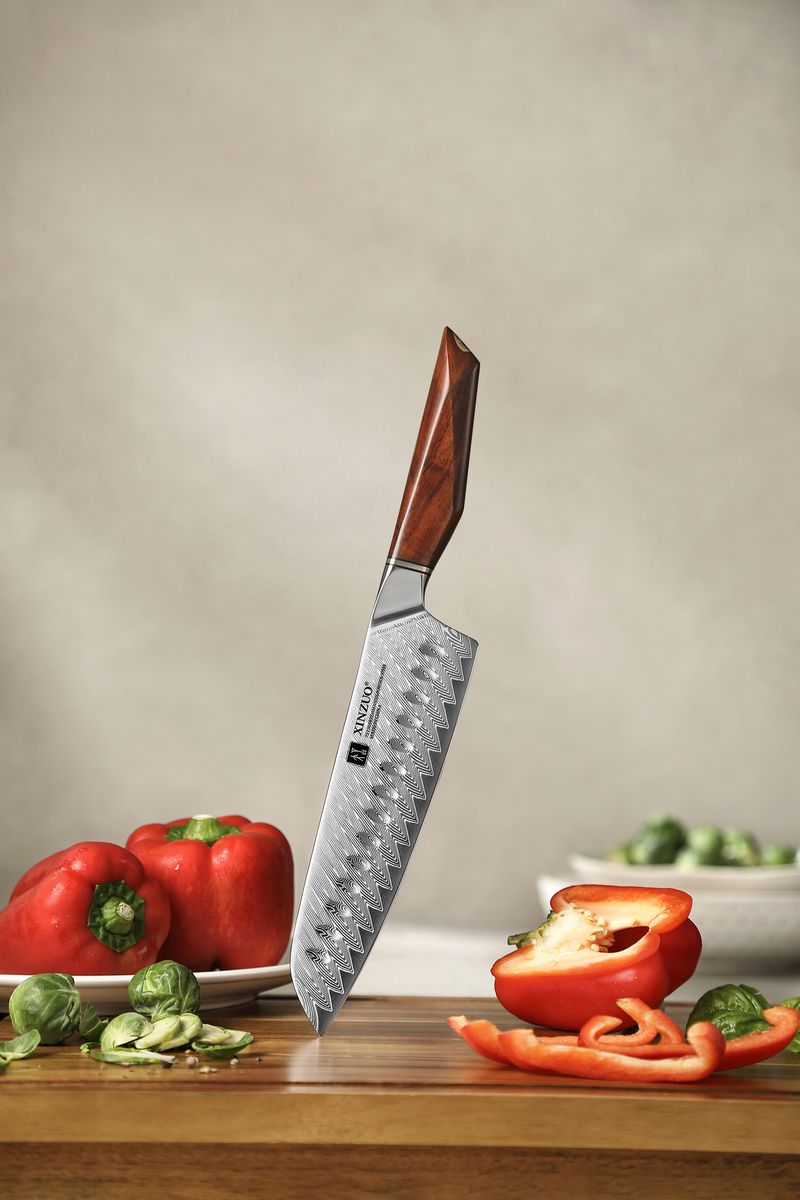 Studio shot of the Santoku knife standing upright, showing the Damascus blade pattern and rosewood handle